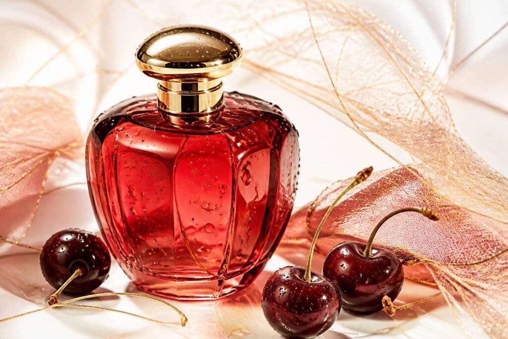 Flacon de parfum générique en verre rouge cerise avec capuchon doré et cerises