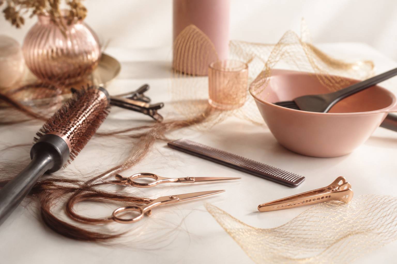 Ciseaux de coiffure, peigne et mèches de cheveux sur un plan de travail de salon