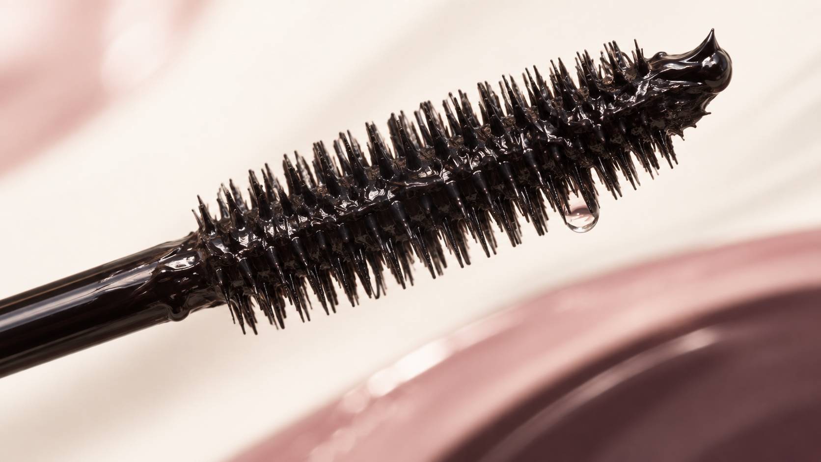 Gros plan macro sur la brosse d'un mascara chargée de formule noire
