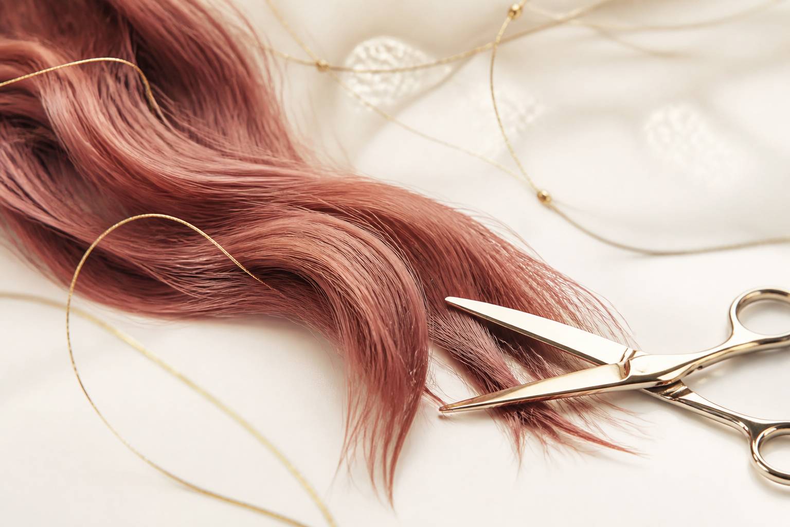 Mèche de cheveux texturée aux pointes effilées avec ciseaux de coiffure professionnels sur fond clair